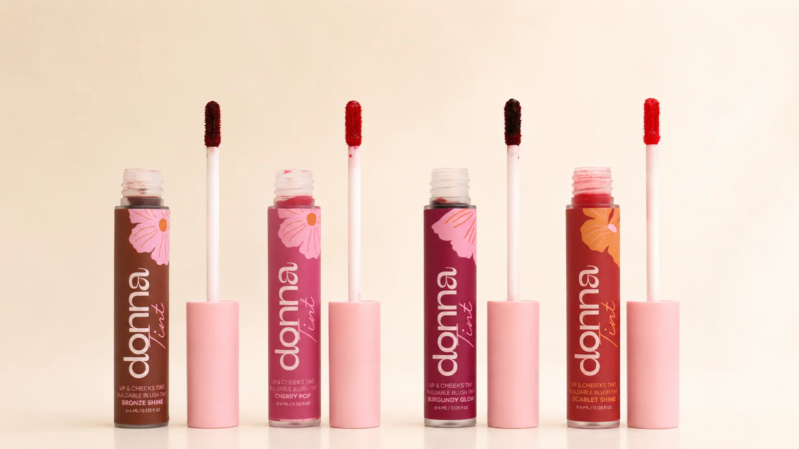 Four open Donna Lip & Cheek Tint shades with their applicators